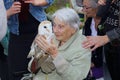 Old demented woman holding bird of prey with tenderness, Netherlands Royalty Free Stock Photo