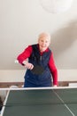 An elderly lady playing table tennis