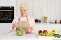 Elderly Lady Preparing Dinner Cooking Standing In Modern Kitchen Royalty Free Stock Photo