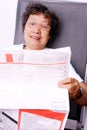 Elderly lady reading newspaper