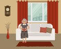 Elderly lady is sitting on the couch and reading a book