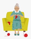 Elderly lady is sitting in yellow armchair and knits socks