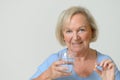 Elderly lady taking the prescribed dose of medicine