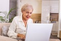 Elderly lady working with laptop. Portrait of beautiful older woman working laptop computer indoors. Senior woman using laptop at Royalty Free Stock Photo