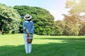 Elderly lifestyle concept. Back of women 50s with hat while holding fruit basket and bouquet of flower in her hands looking Royalty Free Stock Photo