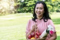 Elderly lifestyle concept. smiling senior women 50s smiling while holding fruit basket and bouquet of flower in her hands Royalty Free Stock Photo