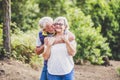 Elderly lifestyle people with couple of caucasian active senior kissing in relationship with green plants nature in background -