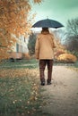 elderly lonely man walking with umbrella in autumn, dementia and amnesia