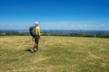 Elderly male hiker walking through a meadow on a bright day Royalty Free Stock Photo