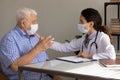 Elderly male patient in facemask consult at doctors office Royalty Free Stock Photo