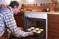 An elderly man in an apron prepares pies Royalty Free Stock Photo