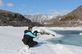 The elderly man with a beard photographing the thawing river