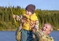 An elderly man with a beard plumped a child up above himself. Royalty Free Stock Photo