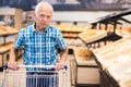 Elderly man buying bread and pastries in grocery section of the supermarket Royalty Free Stock Photo