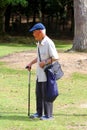 Elderly man cap walking stick park, Japan Royalty Free Stock Photo