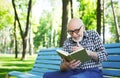 Elderly man in casual reading outdoors Royalty Free Stock Photo