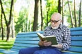 Elderly man in casual reading outdoors Royalty Free Stock Photo