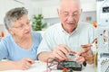 Elderly man checking computer with multimeter Royalty Free Stock Photo
