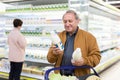 Elderly man chooses milk in supermarket Royalty Free Stock Photo