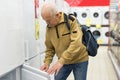 elderly man choosing refrigerator in showroom of electrical appliance store Royalty Free Stock Photo