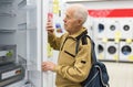 elderly man choosing refrigerator in showroom of electrical appliance store Royalty Free Stock Photo