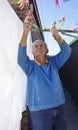 Elderly Man Collecting Pegs From Clothesline. Royalty Free Stock Photo