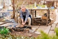 an elderly man cooks barbecue on a grill, a fire. Royalty Free Stock Photo