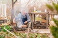 an elderly man cooks barbecue on a grill, a fire. Royalty Free Stock Photo