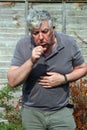 Elderly man coughing. smoking. Royalty Free Stock Photo