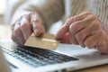 Elderly man with credit card making online purchases on laptop Royalty Free Stock Photo