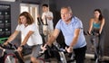 Elderly man doing cardio training on stationary bike in gym Royalty Free Stock Photo