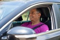 A middle eastern dark skin senior retired man driving a car, portrait from the side. Royalty Free Stock Photo