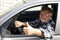 Elderly man driving the car and shows the thumb Royalty Free Stock Photo