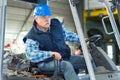 Elderly man driving forklift through warehouse Royalty Free Stock Photo