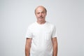 Elderly man emotions, portrait of serious senior caucasian man looking at camera against gray wall