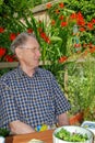 Elderly man enjoys sitting in a garden Royalty Free Stock Photo