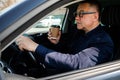 Elderly man experience self-driving smart car and has a cup of coffee Royalty Free Stock Photo