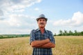 elderly man farmer with a mustache with arms crossed and hat looking at camera and smiling Royalty Free Stock Photo