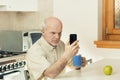 Elderly man finds phone hard to read Royalty Free Stock Photo