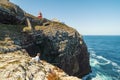 Elderly man fishing with a rod on high cliffs of Sao Vicente Cape, Portugal