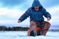 Elderly man fishing in the winter on the lake Royalty Free Stock Photo