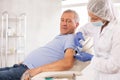 Elderly man getting intramuscular injection in upper arm in medical office Royalty Free Stock Photo