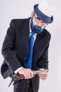 An elderly man in glasses with blue beard holds a huge knife in his hands and looks frighteningly from under his foreheads Royalty Free Stock Photo