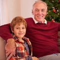 Elderly man, grandson and christmas portrait on sofa with love, bonding or happiness in family home. Boy, grandfather Royalty Free Stock Photo