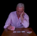 Stressed looking elderly man playing poker