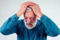 Elderly man with hand on his temple has a headache in studio white background Royalty Free Stock Photo