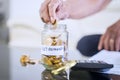 Elderly man hand saving coin in a jar