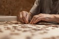 Elderly man hands doing jigsaw puzzle at home Royalty Free Stock Photo
