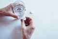 Elderly man hands taking medicine pill with a glass of water Royalty Free Stock Photo