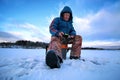 Elderly man fishing in the winter on the lake Royalty Free Stock Photo